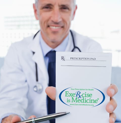 Exerice is Medicineの封筒を見せる笑顔の医師